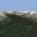 Mountainous Terrain With Snow Covered Peaks And Green Forested Valleys