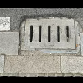 Gray Stone Pavement With Outdoor Drainage Grate And Urban Street Design
