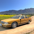 Yellow Sedan Parked On Dirt Road With Yellow Flower Field And Mountains Under Blue Sky