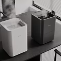 Two Modern Electric Humidifiers White And Black For Home Office Use On Table