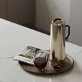 Silver Vacuum Flask As Daily Electrical Appliance On Tray With Glass Cup And Magazine