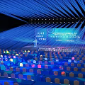 Modern Event Stage Setup With Blue Lighting Colorful Lit Seats Large Screen And Podium