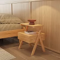 Natural Wooden Bedside Table With Books And Bowl Next To Cozy Bedroom Setup