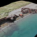Aerial View Coastal Scenery Featuring Shipwreck Remains Sandy Beach Green Grass And Clear Blue Water