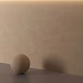 Beige Sphere Placed On Gray Countertop Against Beige Wall Background