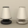 Two Modern Table Lamps With Black And Silver Bases And White Shades