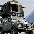 Scenic Mountain Lake View With Off Road Vehicle And Roof Tent On Green Meadow