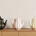 Black Pink and White Ceramic Teapots with Ribbed Design on Wooden Cabinet Light Wall