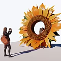 Giant Sunflower Sculpture Featuring Circular Hole With People Inside And Person Taking