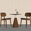 Wooden Table and Chair Set with Round Top Two Chairs Black Cushions Vase and Flower