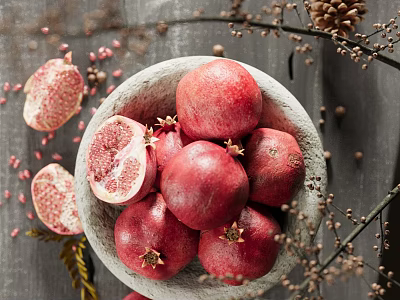 Fresh Pomegranates In Stone Bowl With Halved Fruits Seeds And Decorative Branches 3d model