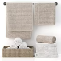 Beige and White Textured Cotton Towels Stacked and Rolled in Woven Basket