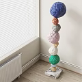 Artistic Colorful Spheres Stacked Sculpture In Indoor Corner With Window Radiator Background