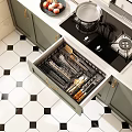 Organized Kitchen Utensils In Open Drawer With Green Cabinets And Black White Tile Floor