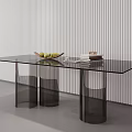 Modern Glass Top Coffee Table With Black Cylindrical Legs Featuring Fruit Bowl And Stacked Books