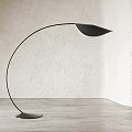 Modern Black Floor Lamp With Curved Stand And Leaf Shaped Shade On Wooden Floor