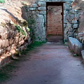 Cartoon Scene Of Ancient Stone Arch With Stone Walls Dirt Path And Weeds