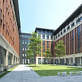Modern School Building Courtyard With Red Brick Facades Glass Walls Green Lawn Trees And Benches