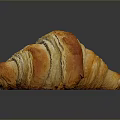 Golden Flaky Croissant On Dark Surface With Shiny Reflection