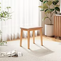 Wooden Stool With Beige Cushion On Rug In Room With White Curtains And Potted Plant