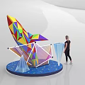 Colorful Geometric Sculpture With Blue Star Pattern Base And Transparent Cones Near Woman