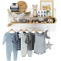 Baby Clothes Hanging On Rack By Wooden Shelf With Decor