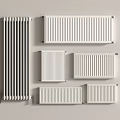 Various Styles And Sizes Of White And Silver Radiators Mounted On Light Colored Wall