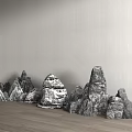 Decorative Rockery Stones With Various Shapes Against Gray Wall On Wooden Floor