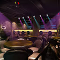 Modern Bar Interior With Colorful Stage Lights Tables And Comfortable Chairs