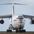 Large Military Transport Aircraft In Flight With Extended Landing Gear And Blue Stripes