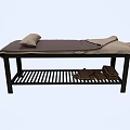Comfortable Massage Bed With Dark Mat and Pillows Underbed Striped Rack and Brown Towels