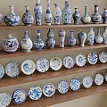 Blue and White Ceramic Wares Displayed on Wooden Shelves with Vases and Plates