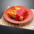 Delicious Lasagna On Red Plate With Woven Placemat And Red Sauce