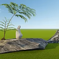 Garden Ornaments Featuring Statue Figures On Large Rocks With Green Grass And Palm Tree