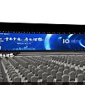 Large Event Venue With Blue Lighting Stage Backdrop Screen And Arranged Chairs