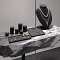 Elegant Jewelry Display Shelf with Necklace Small Black Cylinders Tray on Rock Textured Surface