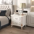 Elegant White Bedside Table with Gold Accents Two Drawers Lamp Books and Decorative Bowl