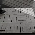 Modern Square Rug With Geometric Line Patterns Gray Black Tones And Light Shadow In Room