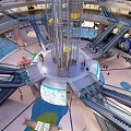 Spacious Hotel Lobby With Central Glass Elevator Multiple Escalators Water Features And Greenery