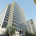 Modern High Rise Office Building Featuring Glass Curtain Walls And Surrounding Trees