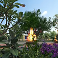 Lush Garden Landscape With Green Trees Purple Flowers Fire Pit Flames And Blue Sky