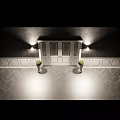 Elegant White Entry Interior With Stained Glass Door Wall Lamps And Green Topiaries