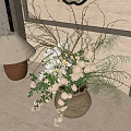 Natural Ceramic Vase With White Flowers Green Foliage And Slender Branches On Tabletop Indoor Setting