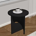 Modern Black Round Top Side Table With White Coffee Cup On Wooden Floor