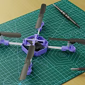 Purple Electric Toy Drone with Black Propellers Displayed on Green Cutting Mat