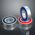 Household Bearings With Silver Blue And Red Rings Stacked On Surface