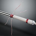 Cylindrical Device With Black White Stripes Red Rings Metal Tip And Thin Wires