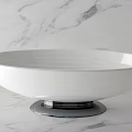 Modern Sleek White Freestanding Bathtub With Chrome Base On Marble Surface