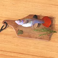 Colorful Freshwater Fish with Red Tail on Wooden Cutting Board and Green Leaf Herbs