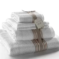 Luxury Stacked White Towels With Brown Stripes And Attached Decorative Tag